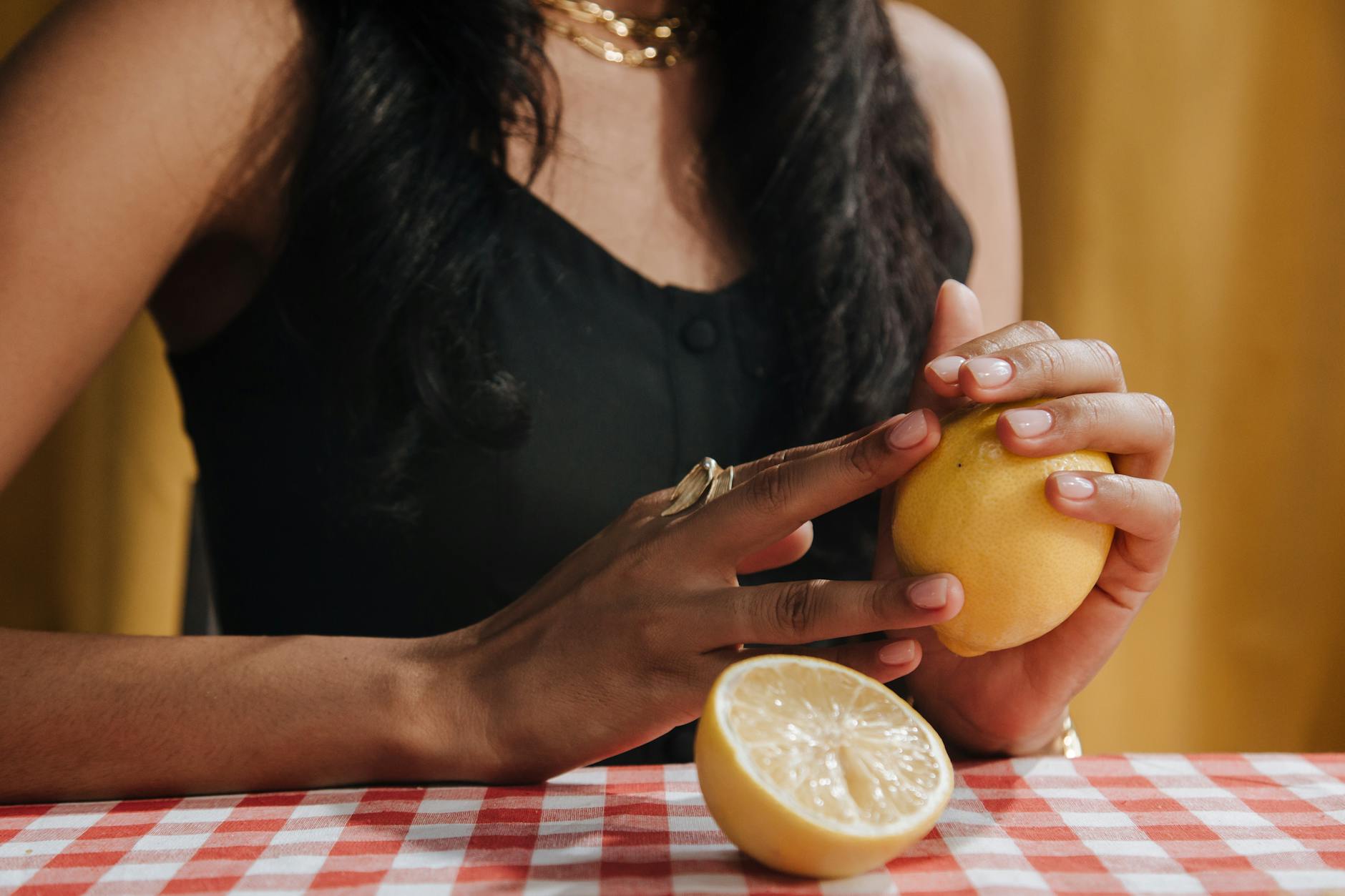 Close-up of hands holding a sleek blue vibrator against a purple background.
