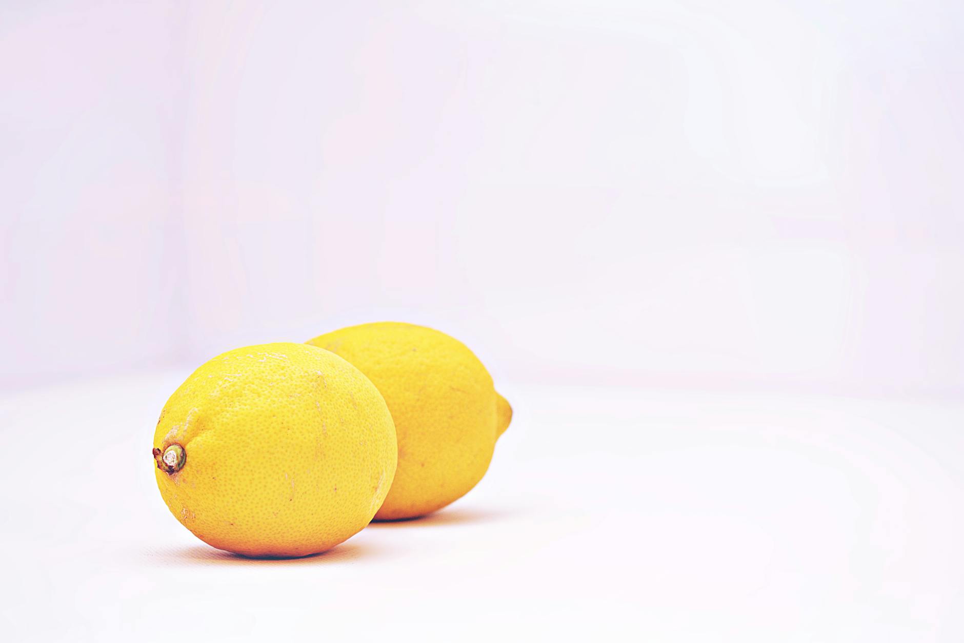 Two vibrant lemons on a white background, symbolizing fresh sensation and natural stimulation