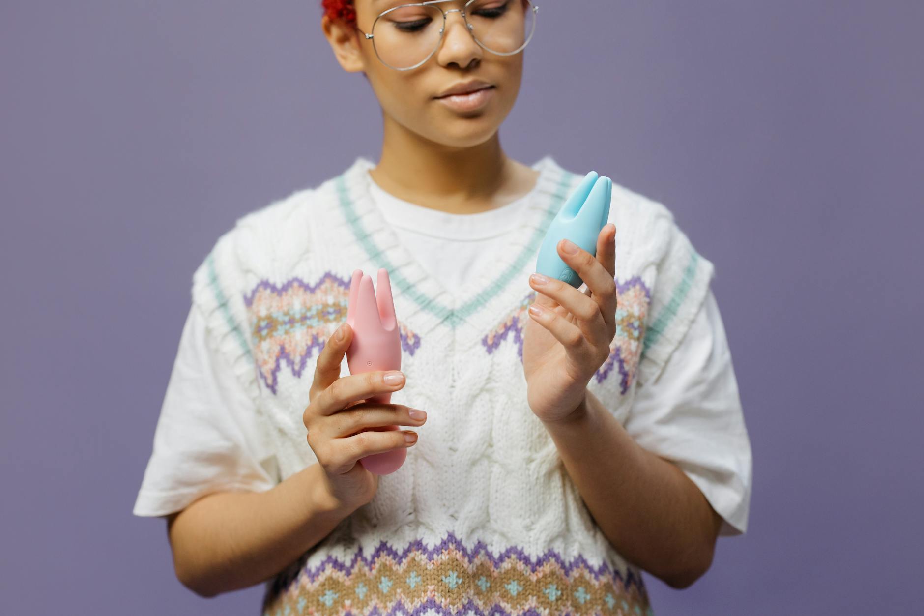 Woman holding blue and pink silicone vibrators, considering how devices can work around medication side effects