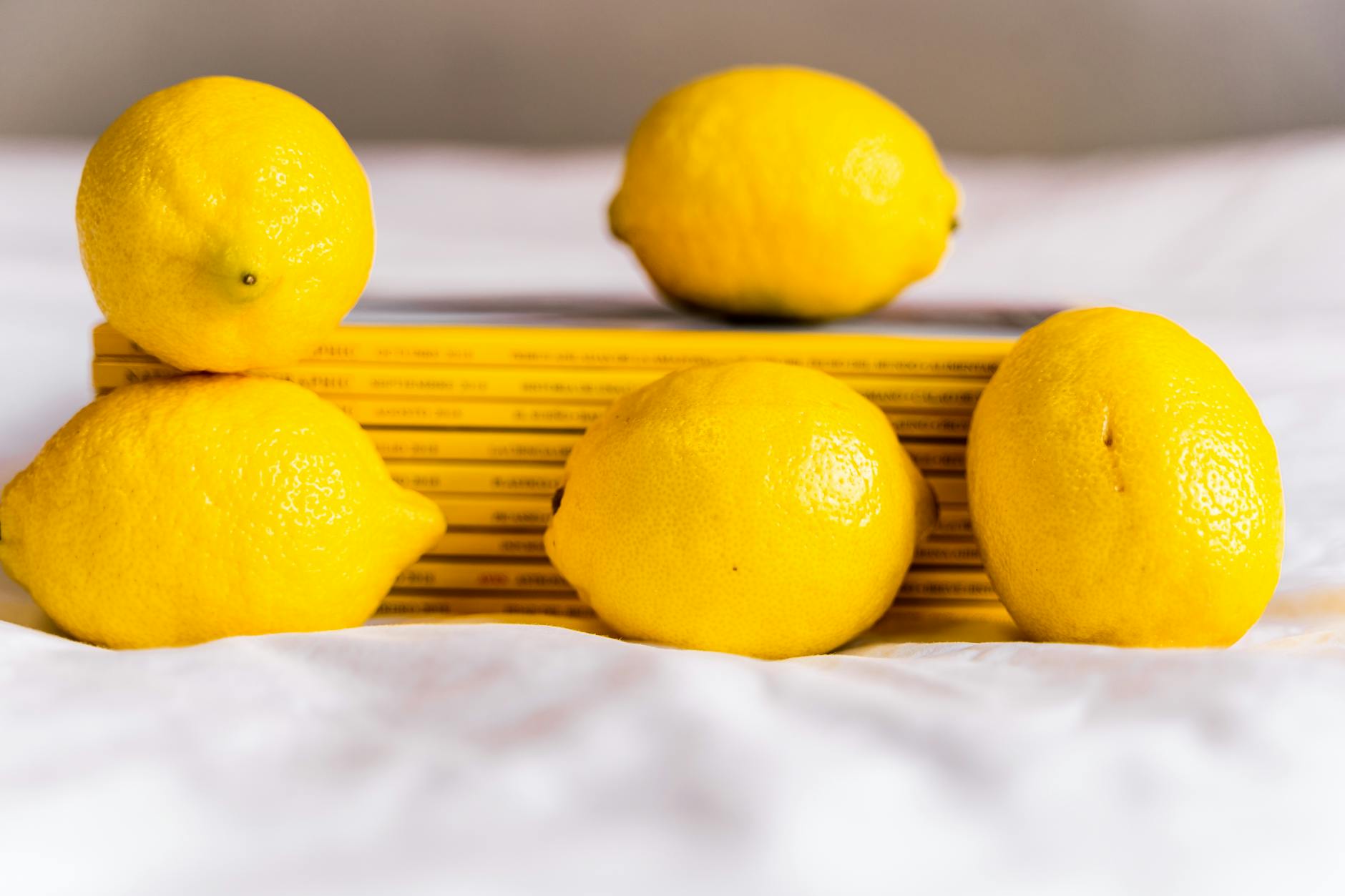 Bright yellow lemons arranged on a soft green background, representing fresh discovery and intentional pleasure.
